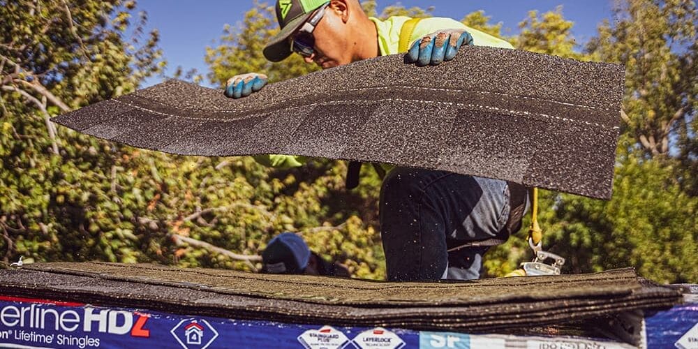 1000x600_Feature-2 man picking up shingles from package